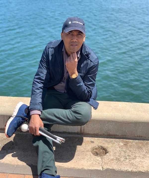 Mosharef proudly holding his white cane. 