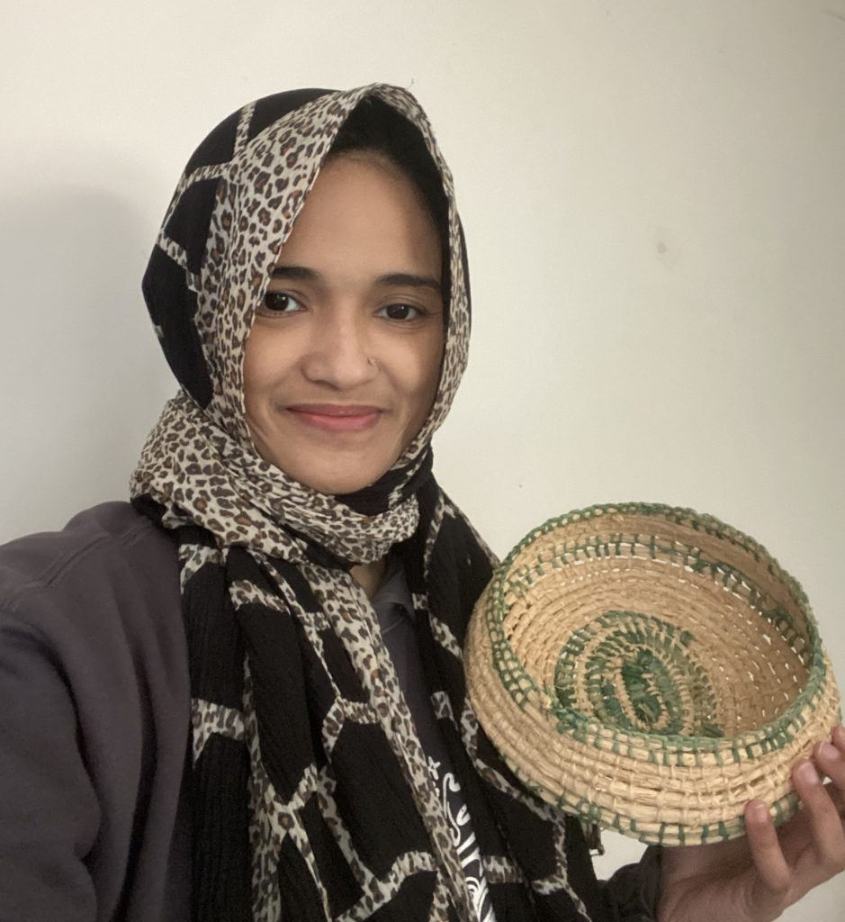 Scholar Julianna holding a traditionally woven basket. 