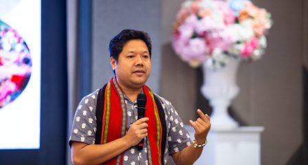 Pallab Chakma speaking into a microphone at an event
