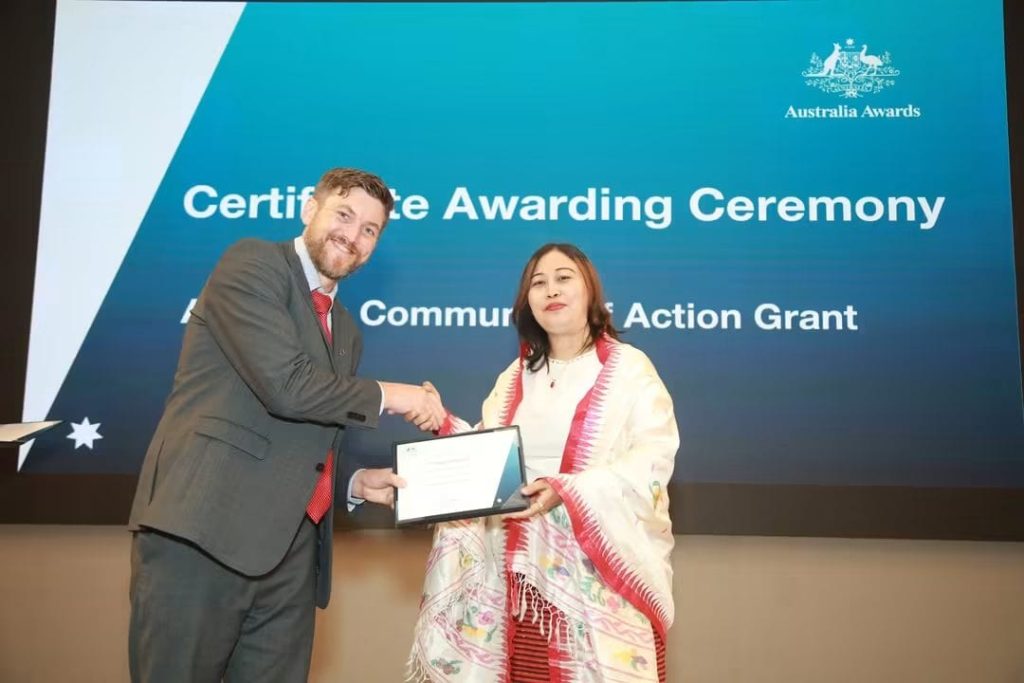 Shaing (right) receiving her Community of Action Grant certificate from Clinton Pobke (left), Deputy High Commissioner of Australia to Bangladesh.
